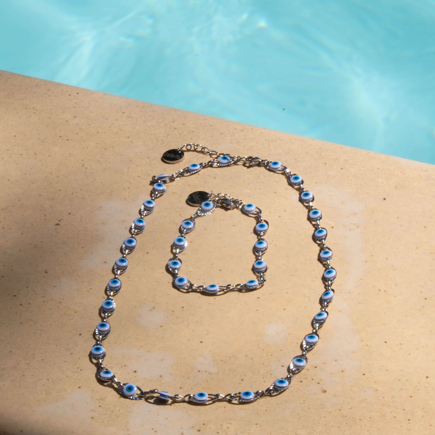 Parure contenant bracelet et collier femme en acier inoxydable, époxy blanc, bleu clair et bleu, bijou élégant et résistant.